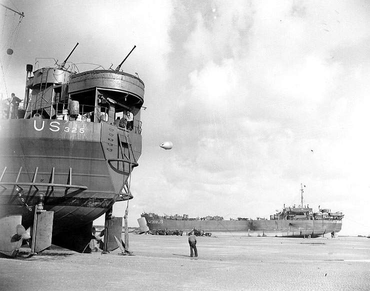 LST-325 unloading while stranded at low tide during resupply operations in Normandy, France, on 12 June 1944.