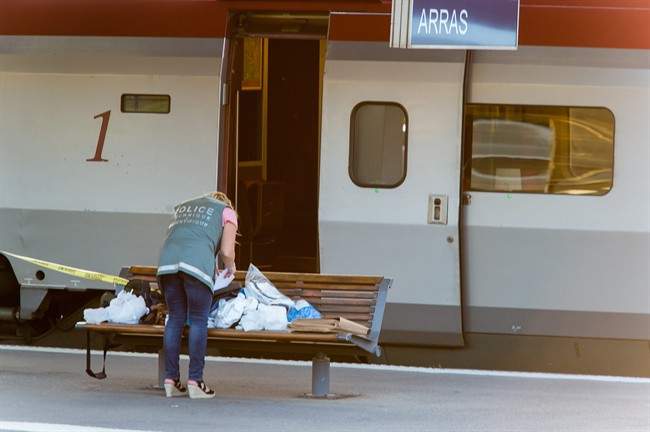 A police officer works on a platform near a Thalys train of French national railway operator, SNCF, at the main train station in Arras, northern France, after a gunman opened fire injuring three passengers.