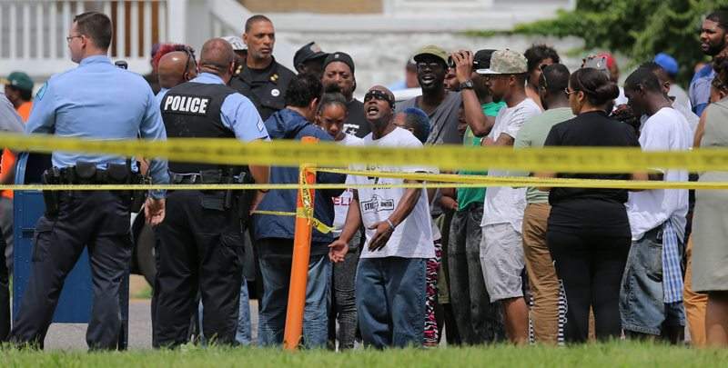 People confront police at the scene of a fatal officer-involved shooting at Walton Avenue and Page Boulevard on Wednesday, Aug. 19, 2015 in St. Louis. An armed man fleeing from officers serving a search warrant at a home in a crime-troubled section of north St. Louis was shot and killed Wednesday by police after he pointed a gun at them, the police chief said. 