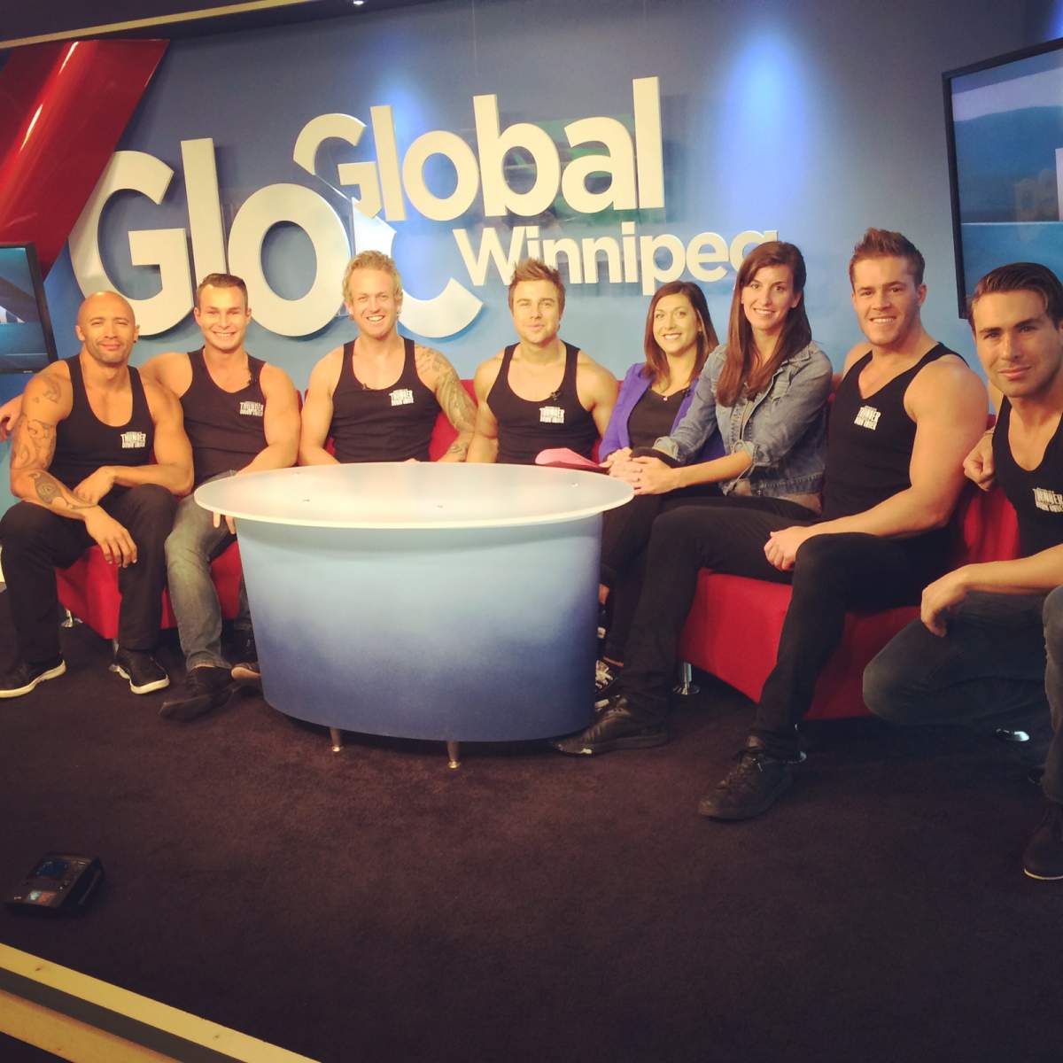 Australian dance group, Thunder from Down under, joins Global's Morning News anchor Hiolly Alexandruk and Producer Katie Dangerfield on set for a photo.