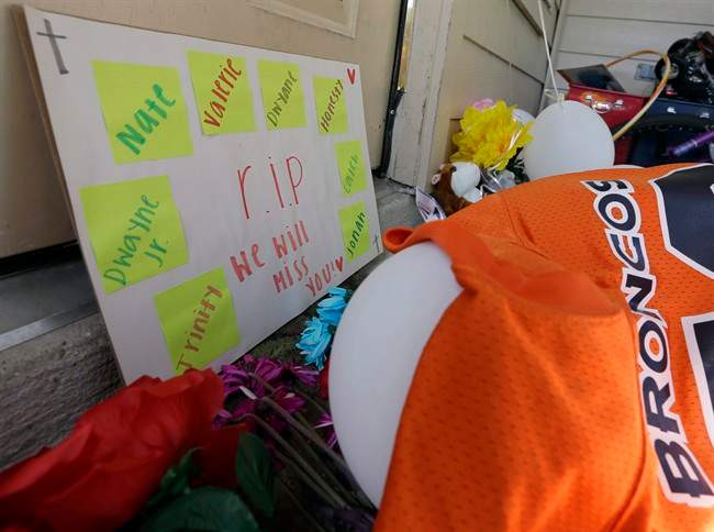 A sign sits against the door Monday, Aug. 10, 2015, as part of the condolences left outside the home where eight people were shot over the weekend in Houston.