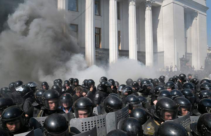 Smoke rises from outside the parliament building as riot police clash with protestors, after the vote to give greater powers to the east in front of the Parliament, in Kiev, Ukraine, Monday, Aug. 31, 2015.  (AP Photo/Efrem Lukatsky)