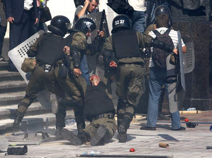 Police officers carry their injured colleague after grenade exploded during a clash between protesters and police after vote to give greater powers to the east, outside the Parliament, Kiev, Ukraine, Monday, Aug. 31, 2015.  (AP Photo/Vladimir Donsov)