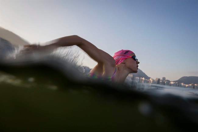 A triathlete trains in the waters off Copacabana Beach, despite published warnings that water in the area was "unfit" for swimming, in Rio de Janeiro, Brazil, Friday, July 31, 2015. 