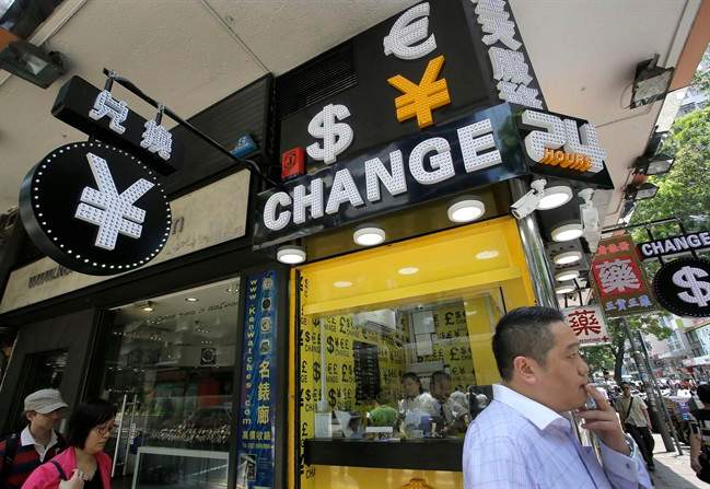 A man walks past a currency exchange shop in Hong Kong, Tuesday, Aug. 11, 2015. China devalued its tightly controlled currency Tuesday following a slump in trade, allowing the yuan\’s biggest one-day decline in a decade.