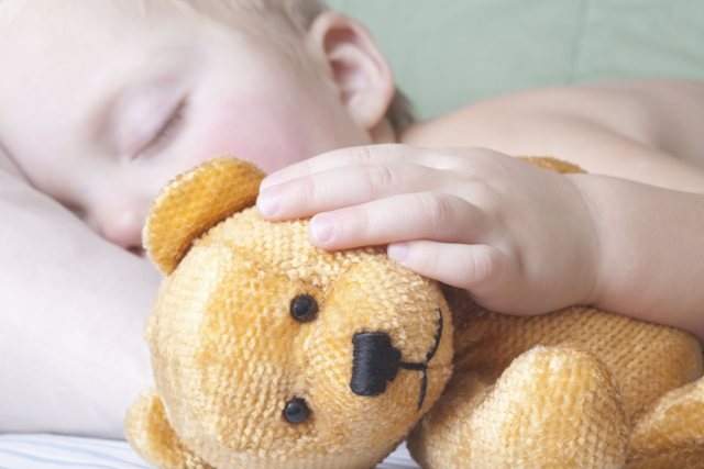 FILE: A child holds a teddy bear. 