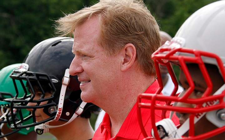 NFL commissioner Roger Goodell poses with youth football players after they received new helmets in Akron, Ohio. 