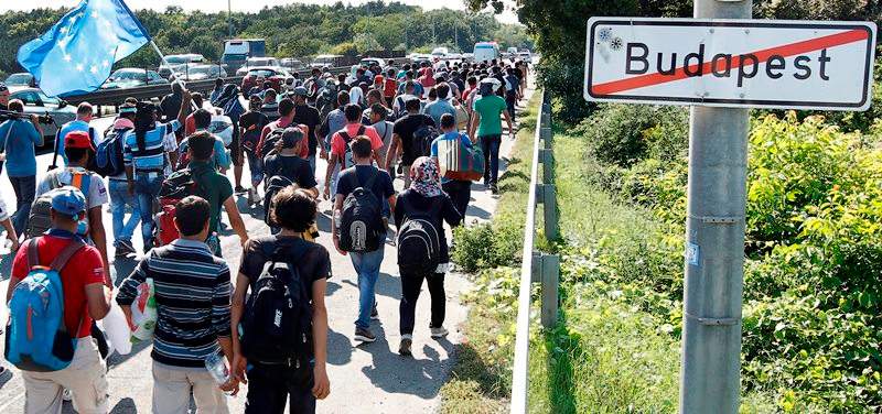 Migrants walk out of Budapest, Hungary, Friday, Sept. 4, 2015. Several thousand migrants left the Keleti railway station in Budapest this afternoon heading for Germany on foot.