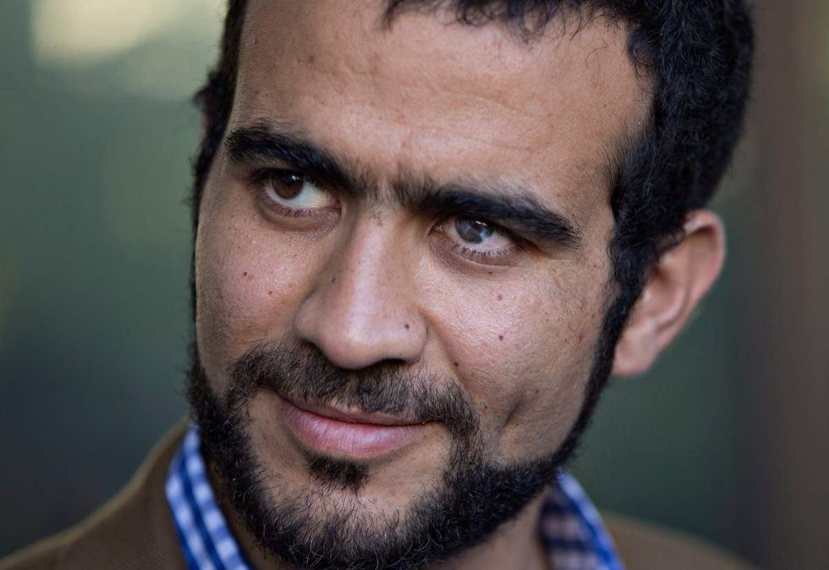 Omar Khadr watches as his lawyer Dennis Edney speaks to media after his bail conditions hearing in Edmonton on Friday, September 11, 2015. 