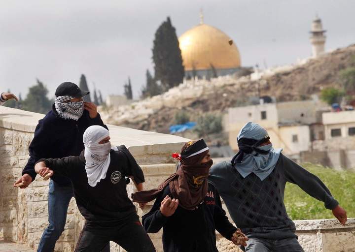 FILE - In this March 16, 2010 file photo, Palestinian demonstrators hurl stones at Israeli troops in east Jerusalem. After finding high-tech solutions to halt suicide bombings and rockets, tech-savvy Israel is struggling with the resurgence of a weapon dating back to David and Goliath: the hurled rock. The Palestinian rock thrower emerged as an iconic image of the first uprising against Israeli occupation in the 1980s, and rock throwing has been a regular feature of demonstrations since then. (AP Photo/Dan Balilty, File).