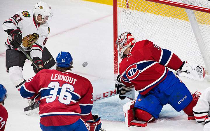 Montreal Canadiens goaltender Carey Price, right, is scored on by Chicago Blackhawks' Garrett Ross, as Canadiens' Brett Lernout defends during first period NHL pre-season hockey action in Montreal, Friday, September 25, 2015. 