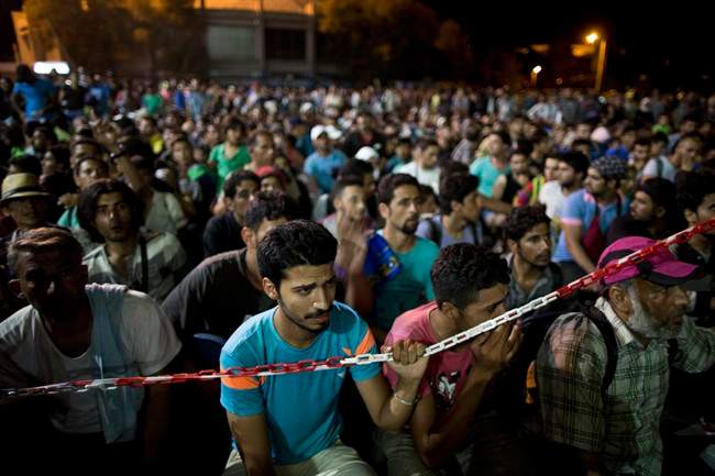 Syrian refugees wait at the port of Lesbos island, Greece, to board a ferry travelling to Athens, on Monday, Sept. 7, 2015. An immigration expert says recent announcements of provincial support for Syrian refugees fail to address the question of who would foot the bill to sponsor more immigrants from the war-ravaged country. THE CANADIAN PRESS/AP/Petros Giannakouris.