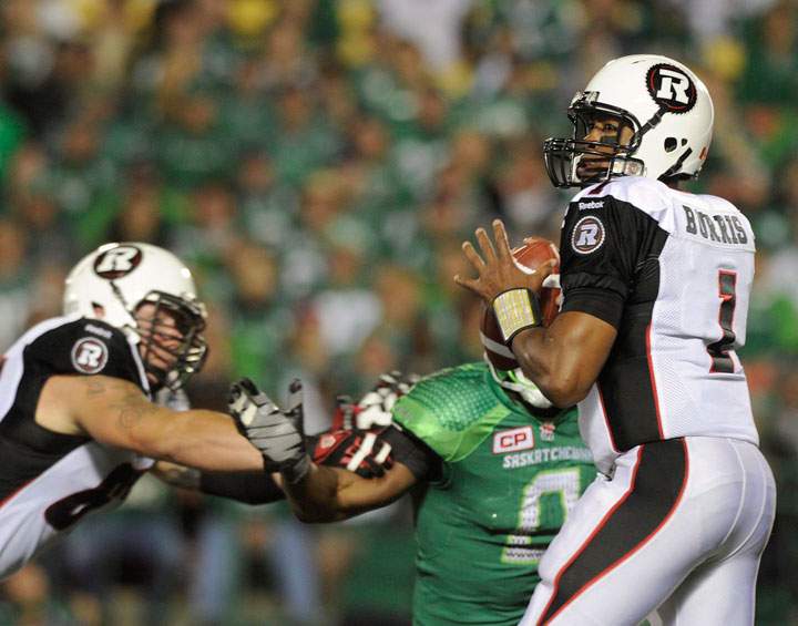 Ottawa Redblacks quarterback Henry Burris works under pressure against the Saskatchewan Roughriders during first half CFL action in Regina on Saturday, September 19, 2015.