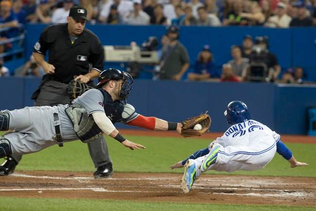 Toronto Blue Jays' Josh Donaldson, right, slides into home to score past Cleveland Indians catcher Yan Gomes after a sacrifice fly from Blue Jays' Troy Tulowitzki during second inning AL baseball action in Toronto on Wednesday September 2 , 2015. THE CANADIAN PRESS/Chris Young.
