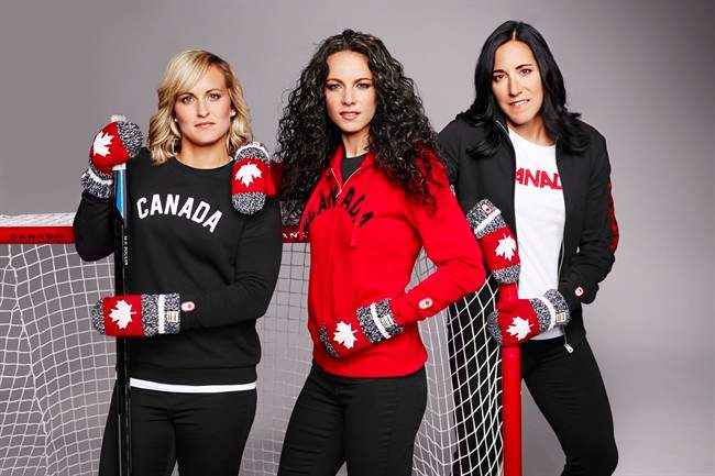 Canadian women's hockey team members Marie-Philip Poulin, left to right, Shannon Szabados and Caroline Ouellette pose as they show off the seventh edition of the Hudson's Bay Olympic red mittens in this undated handout photo.