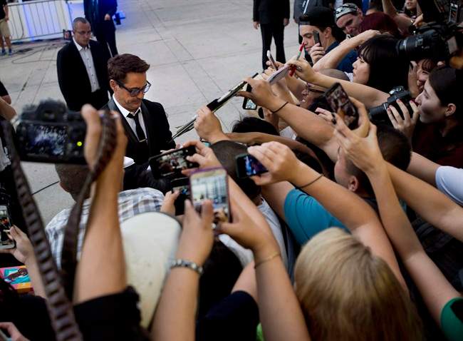 Actor Robert Downey Jr., centre, signs autographs for fans after arriving on the red carpet for his new movie "The Judge" during the 2014 Toronto International Film Festival in Toronto on Thursday, September 4, 2014. Starting Thursday, Toronto will host its 40th TIFF.