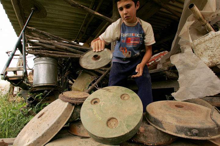 Djuka Dretvic, 14, plays with anti-tank landmines found in front of his family house in the village of Ceric, close to the eastern Croatian town of Vukovar in Sept. 2006. (File photo)