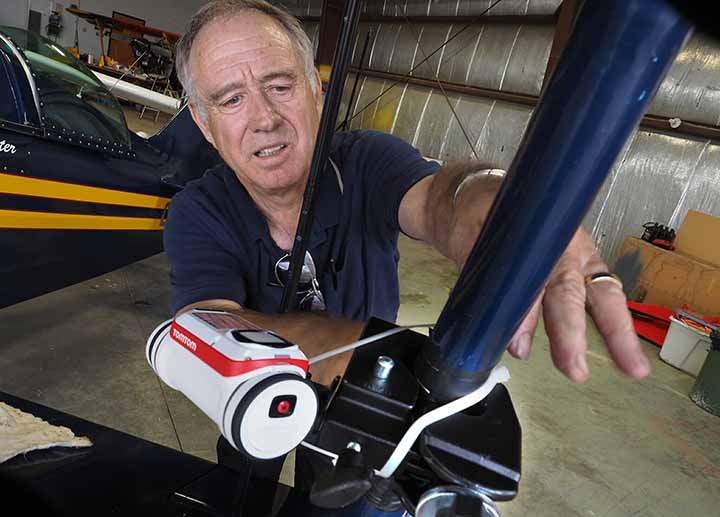 Former Air Canada pilot Bill Carter checks the mount on the TomTom Bandit action can on the wing strut of his Pitts Special S2S before his signature 12 minute aerobatic show at Vileneuve Airport