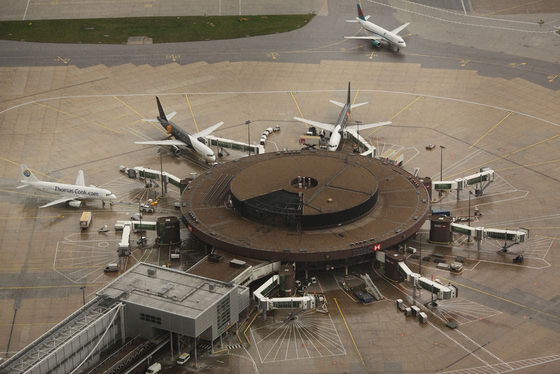 Passenger aircraft surround satellite gates at Gatwick Airport.