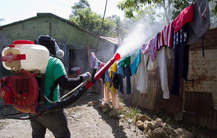 A man fumigates between houses at the Santo Domingo's neighborhood La Barquita to fight dengue fever.