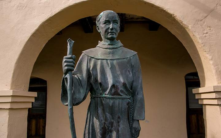 A bronze sculpture of Father Junipero Serra stands at entrance to Mission Santa Ines on December 24, 2014, in Solvang, California.