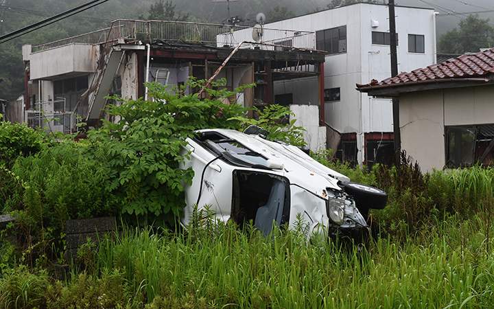 This photo taken on July 16, 2015 shows a vehicle and houses damaged by the March 11, 2011 tsunami still untouched after four years, in the village of Tomioka north of Naraha in Fukushima prefecture. 