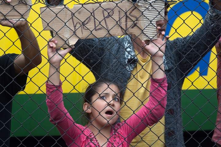 Migrants protest outside a train that they are refusing to leave for fear of being taken to a refugee camp from the train that has been held at Bicske station since yesterday on September 4, 2015 in Bicske, near Budapest, Hungary. (Photo by Matt Cardy/Getty Images).