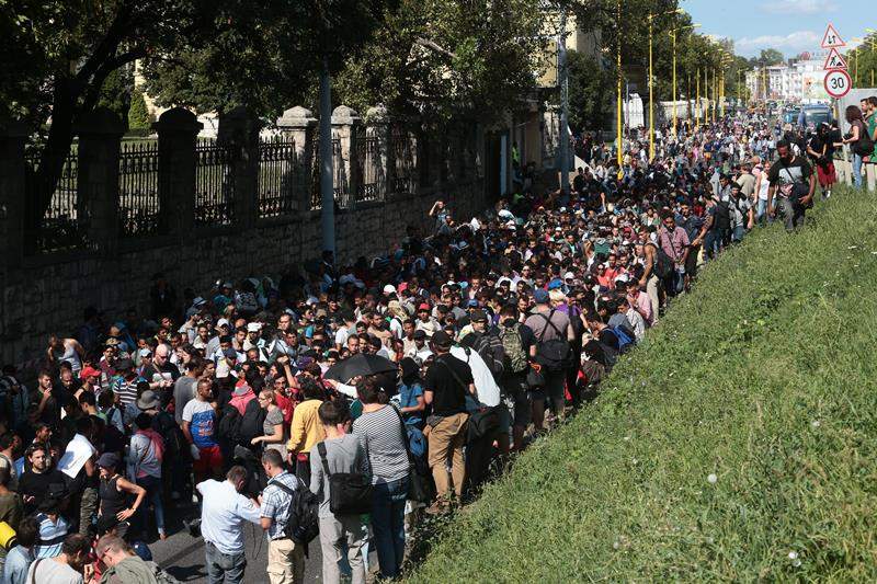 Hundreds of migrants walk after leaving the transit zone of the Budapest main train station.