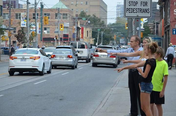 Norm Kelly demonstrate the finger pointing technique for pedestrians  at crosswalks.