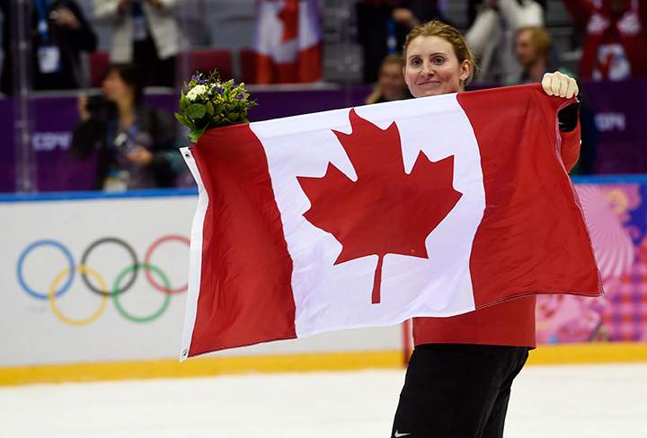 Hayley Wickenheiser holds up a Canadian flag following the medals ceremony at the women’s gold medal hockey game at the Sochi Winter Olympics Friday February 21, 2014 in Sochi, Russia.