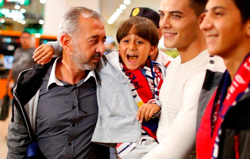 Syrian Osama Abdul Mohsen, left, holds his son Zaid as they arrive at the Barcelona train station on Wednesday, Sept.16, 2015.  