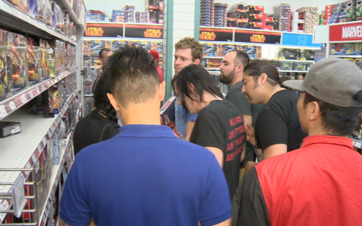 A crowd of shoppers surround a Star Wars toy display at a Toys "R" Us store in Toronto, Canada on Sept. 4, 2015.