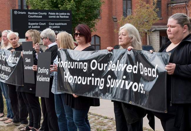 Mourners opposing violence against women stand in solidarity at the courthouse in Pembroke, Ont. on Wednesday, Sept. 23, 2015, as Basil Borutski, 57, who led police on a five hour manhunt Tuesday and is accused of killing three women, is set to appear in court. 