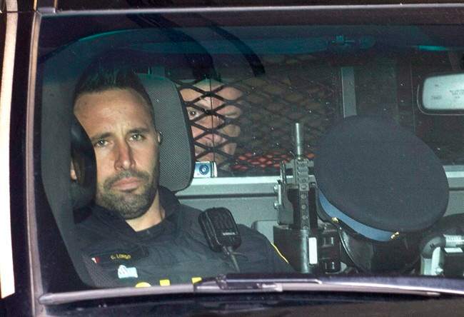 Basil Borutski looks out from behind the mesh enclosure in the back of a police vehicle after appearing at the courthouse in Pembroke, Ont. on Wednesday, Sept. 23, 2015. Borutski has been charged with three counts of first-degree murder in the separate slayings of three women whose deaths sparked a lockdown and manhunt in an ordinarily peaceful area of eastern Ontario.