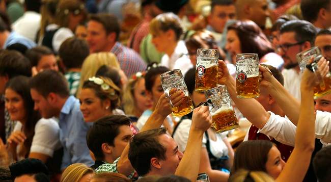 People cheer during the opening of the 182. Oktoberfest beer festival in Munich, southern Germany, Saturday, Sept. 19, 2015.