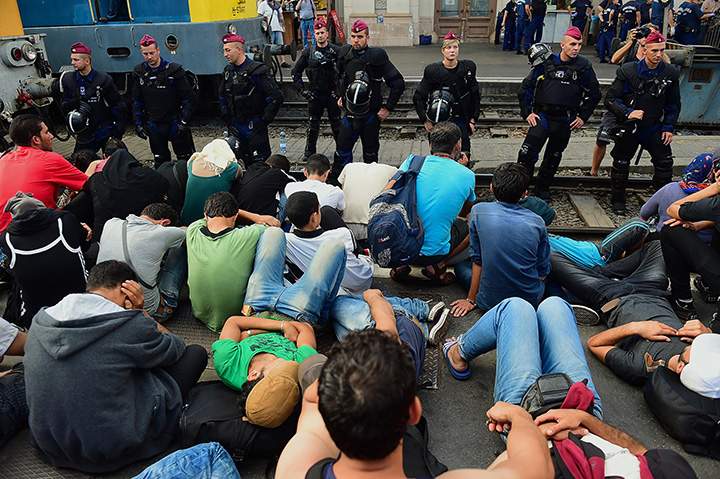 Riot police stand on train track as they monitor migrants and refugees at the Keleti (eastern) railway station in Budapest on September 1, 2015.
