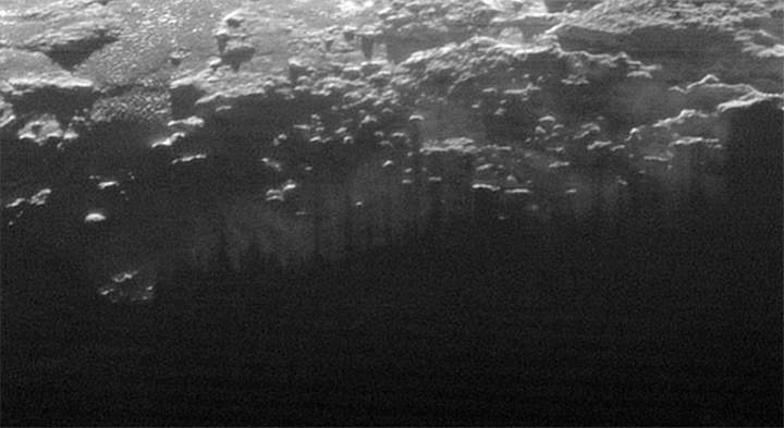 In this small section of the larger crescent image of Pluto, taken by NASA’s New Horizons just 15 minutes after the spacecraft’s closest approach on July 14, 2015, the setting sun illuminates a fog or near-surface haze, which is cut by the parallel shadows of many local hills and small mountains.