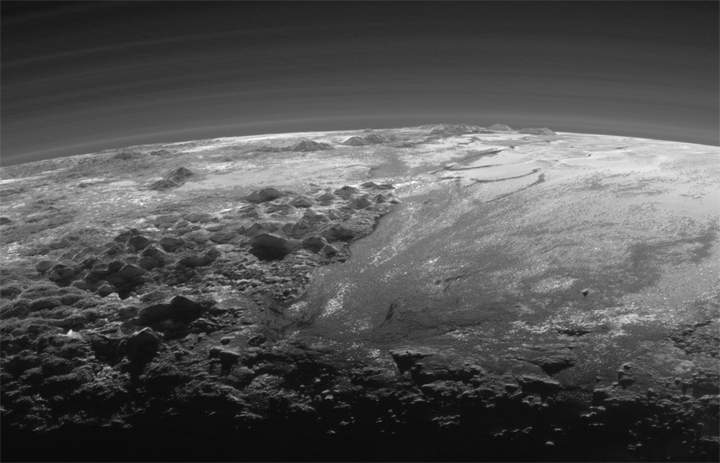 Just 15 minutes after its closest approach to Pluto on July 14, 2015, NASA’s New Horizons spacecraft looked back toward the sun and captured this near-sunset view of the rugged, icy mountains and flat ice plains extending to Pluto’s horizon.