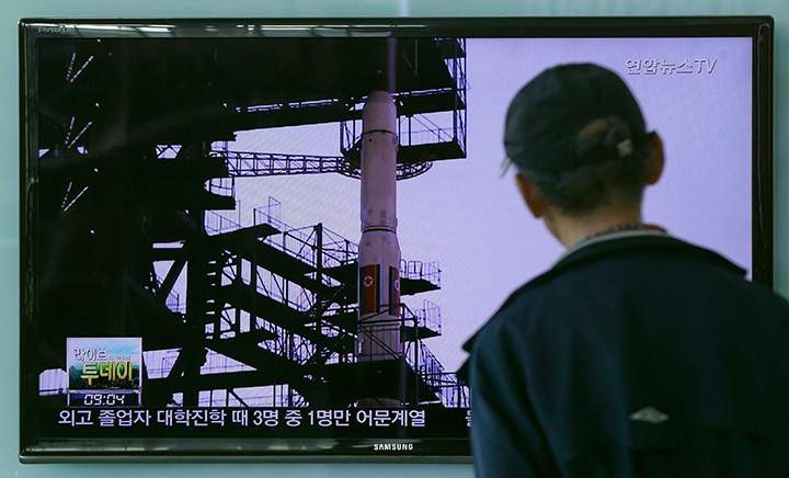 A South Korean man watches TV news program showing file footage of the Unha rocket in North Korea. 
