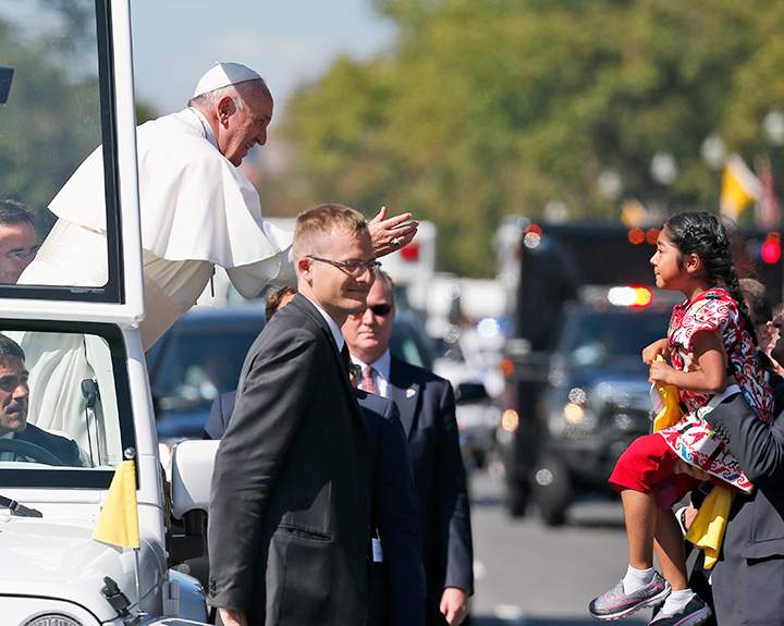 In this Sept. 23, 2015, photo, Pope Francis reaches to give a blessing to Sophie Cruz, 5, from suburban Los Angeles, during a parade in Washington.