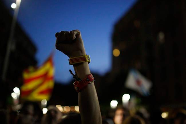 A Catalonian independence supporter wearing a bracelet with the "estelada" or pro independence flag colours, raises her fist during reactions after the vote in Barcelona, Spain, Sunday Sept. 27, 2015. Voters in Catalonia participated in an election Sunday that could propel the northeastern region toward independence from the rest of Spain or quell secessionism for years. Secessionists have long pushed for an independence referendum, but Spain's central government has not allowed one, arguing it would be unconstitutional because only it can call such a vote. (AP Photo/Emilio Morenatti).
