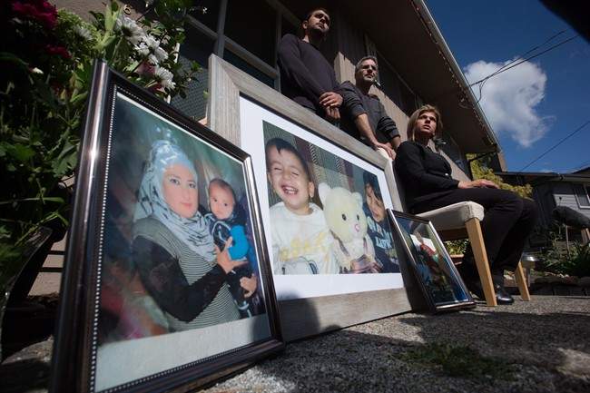 Tima Kurdi, right, aunt of late brothers Alan and Ghalib Kurdi, pauses while speaking to the media outside her home as her son Alan Kerim, left, and husband Rocco Logozzo stand behind her, in Coquitlam, B.C., on Friday September 4, 2015. Alan, his older brother Ghalib and their mother Rehanna died as they tried to reach Europe from Syria.
