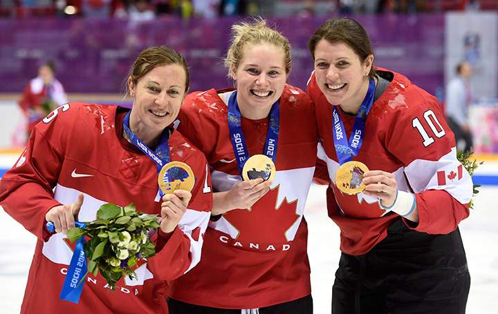 Team Canada’s Jayna Hefford, left to right, Haley Irwin and Gillian Apps show off their gold medals after defeating Team USA in the women’s gold medal hockey game at the Sochi Winter Olympics in Sochi, Russia, on February 21, 2014.