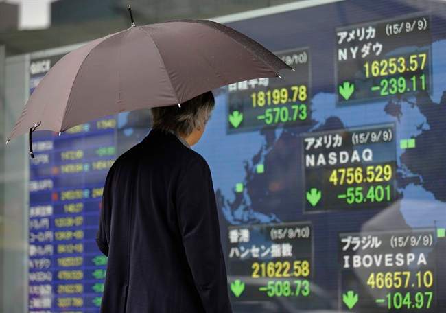 A man looks at an electronic stock indicator of a securities.