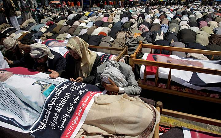 Relatives and anti-government protestors pray over the coffins of protesters killed during recent clashes with security forces during thier funeral procession in Sanaa, Yemen, Sunday, Sept. 25, 2011.