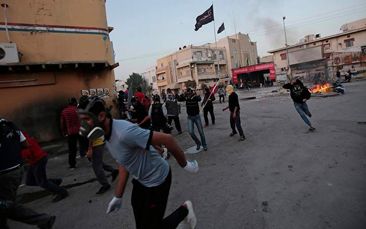 Bahraini anti-government protesters, some carrying national flags, run from an approaching armored police vehicle during clashes in Bilad Al Qadeem, Bahrain on Jan. 30, 2015.
