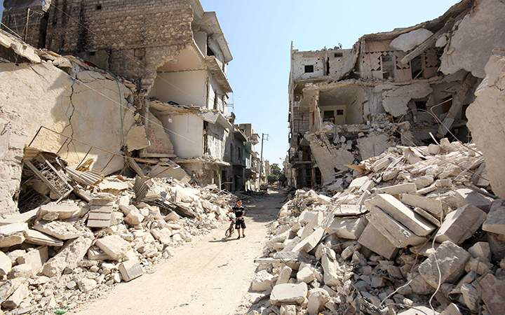 A Syrian boy plays between the rubble of destroyed houses following a reported barrel-bomb attack by Syrian government forces, in the Tariq al-Bab neighbourhood in the northern city of Aleppo on Aug. 21 2015.