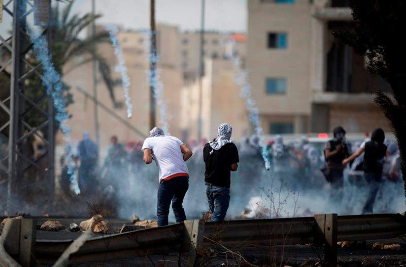 Tear gas rain down on Palestinians during clashes with Israeli troops near Ramallah, West Bank, Saturday, Oct. 10, 2015. Palestinians carried out two stabbing attacks in Jerusalem on Saturday before being shot dead by police, while another two Palestinians were killed during a violent demonstration near the Gaza border fence, the latest in a series of stabbing attacks against civilians and soldiers that have spread across Israel and the West Bank in the past week