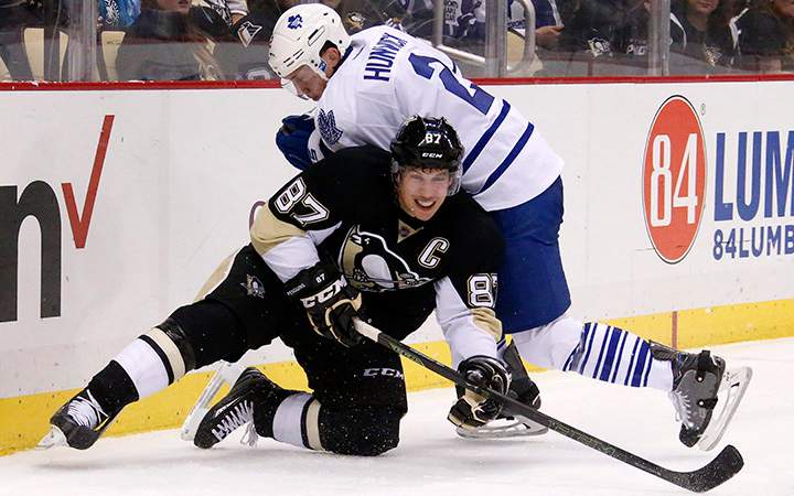 Pittsburgh Penguins' Sidney Crosby gets off a pass with Toronto Maple Leafs' Matt Hunwick on top of him during the second period of an NHL hockey game in Pittsburgh, Saturday, Oct. 17, 2015.