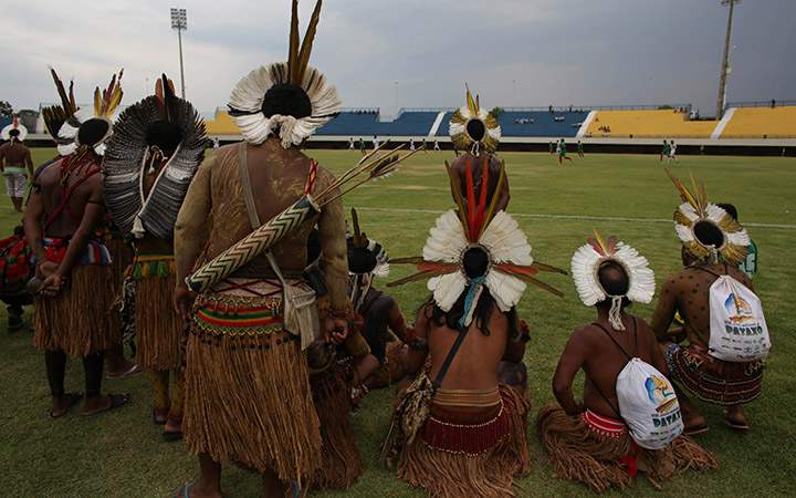 Pataxo men watch a soccer match against a fellow Brazilian tribe, Xerente, during the World Indigenous Games, in Palmas, Brazil, Friday, Oct. 23, 2015. Hundreds of indigenous people from across Brazil and delegations from as far afield as Mongolia and the Philippines have already arrived for what has been billed as the first "indigenous Olympics.".